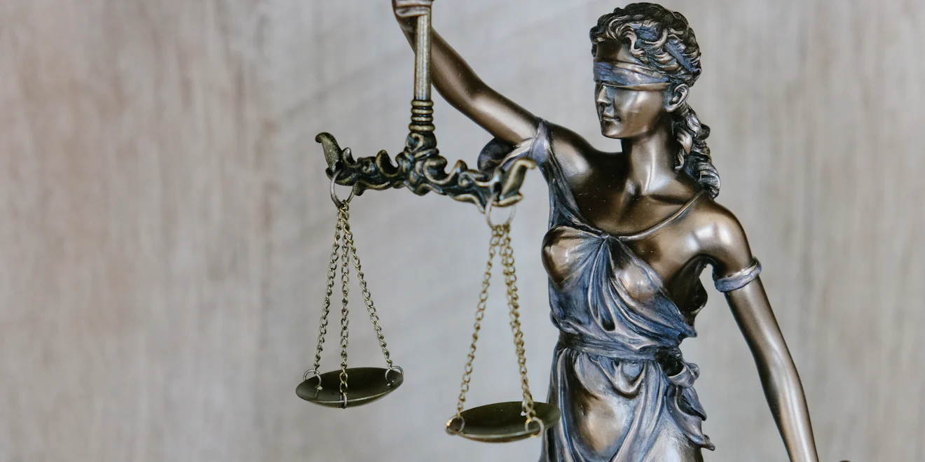 Bronze statue of Lady Justice holding balanced scales